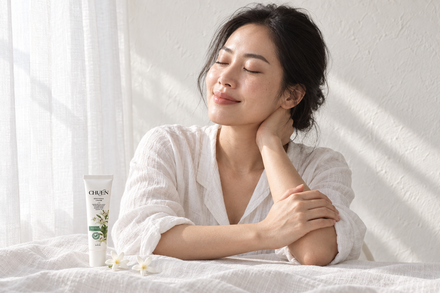 A woman taking a moment for self-care beside CHUEN products and white linen