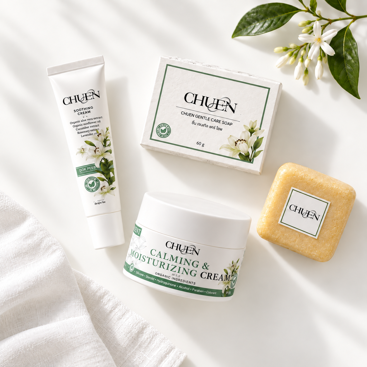 The three CHUEN products on white linen with delicate flowers